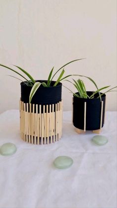 two black and white planters sitting on top of a table next to each other