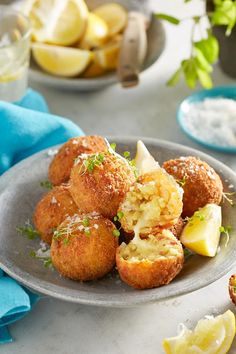 some food is sitting on a plate with lemon wedges and parmesan cheese