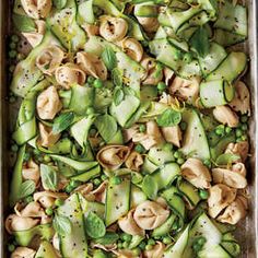 a pan filled with pasta and vegetables on top of a table