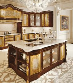 a fancy kitchen with chandelier and marble counter tops in the middle of it