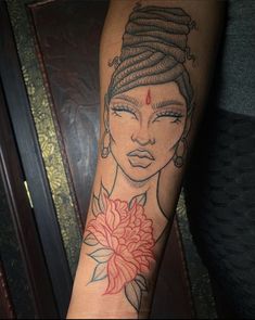 a woman's arm with a tattoo on it and a flower in her hair