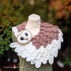 a white and brown owl scarf on top of a mannequin headdress