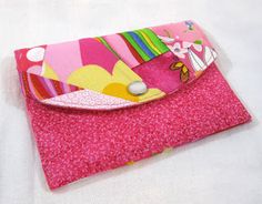 a pink wallet sitting on top of a white table next to a cell phone holder