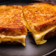 two grilled cheese sandwiches on a black plate