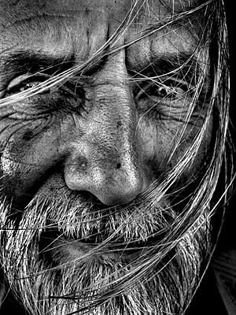 black and white photograph of an old man's face with hair blowing in the wind