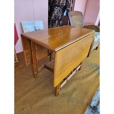 an old wooden desk with two chairs in the background