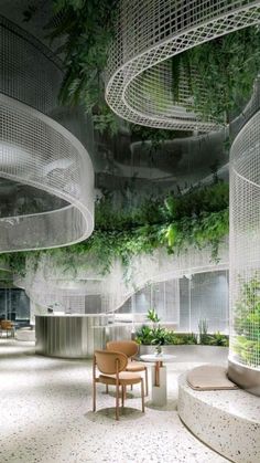 the interior of an office building with plants growing on the walls and ceiling, as well as chairs