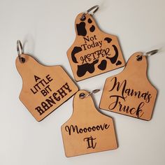 four wooden name tags with different designs on them