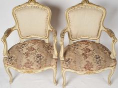 two antique chairs with floral upholstering and gold trimmings on them