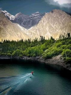 a person on a jet ski in the water with mountains in the backgroud