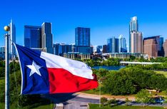 the texas state flag is flying in front of a cityscape with tall buildings