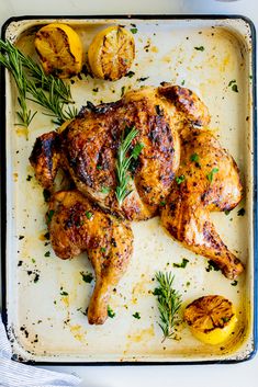 roasted chicken with lemons and herbs on a baking sheet