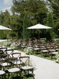 chairs and umbrellas set up for an outdoor ceremony