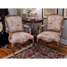 two chairs sitting next to each other on top of a rug