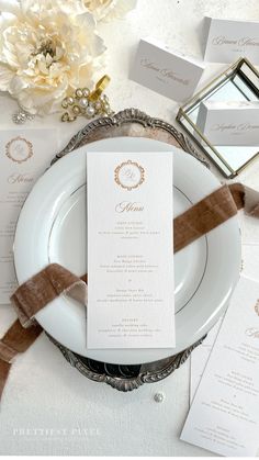 a white plate topped with a menu on top of a table next to napkins