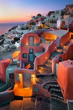 an aerial view of some buildings and the ocean at sunset in oia, kaua'i