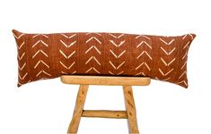 a brown and white pillow sitting on top of a wooden stool