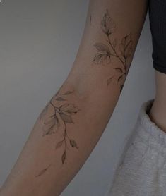 a woman's arm with leaves on it