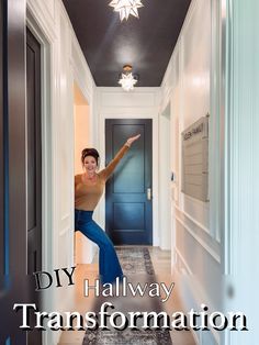 a woman is standing in the hallway with her arms out and pointing to the ceiling