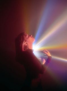 a woman standing in front of a colorful light