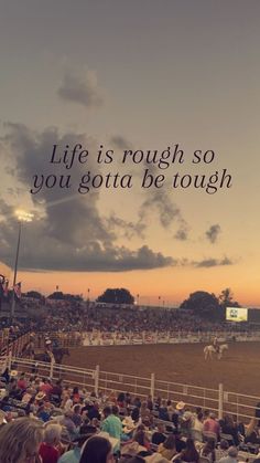 a crowd of people sitting in chairs watching a horse race at sunset with the words life is rough so you got a be tough