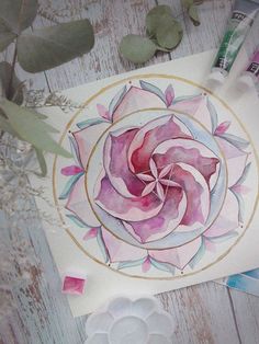 a watercolor painting of a pink rose in a circle surrounded by other paint supplies