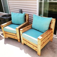 two wooden chairs sitting next to each other on a patio