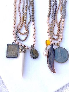 "Three individual necklaces are hand-strung, Metallic and Matte Beads are mixed together in size and color for a beautiful palette of texture and design. To compliment these colors, I've chosen two different Charm Packages: 1. Square Buddha Replica Labradorite Gunmetal Bezel Silver Plated Bone (resin) Tooth OR 2. Replica Buddha Coin Vermeil Bezel Citrine with Freshwater Pearl Carved Horn Feather All six pendants have been very popular on their own when used in other stylings! You can choose to w Spiritual Multi-strand Beaded Chain Necklace, Unique Long Beaded Necklace With Faceted Beads, Bohemian Necklace With Oval Faceted Beads, Bohemian Beaded Necklace With Faceted Oval Beads, Unique Multi-strand Faceted Beaded Necklaces, Bohemian Double Strand Faceted Beads Necklace, Unique Multi-strand Beaded Necklaces With Faceted Beads, Spiritual Double Strand Beads For Jewelry Making, Handmade Spiritual Double Strand Beaded Necklaces