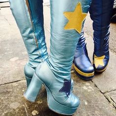 two people wearing blue and yellow boots with stars on the bottom, one person's legs