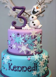 a birthday cake decorated with snowflakes and two frosting figures for the number three