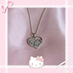 a hello kitty necklace with two hearts attached to it's sides, on a pink background