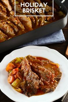 a white plate topped with meat and veggies next to a roasting pan