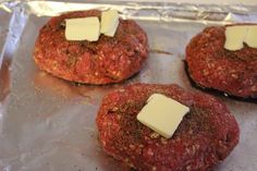 four hamburger patties topped with cheese on top of aluminum foil covered in tinfoil