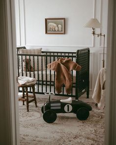 a baby's room with a crib, rocking chair and teddy bear on the floor