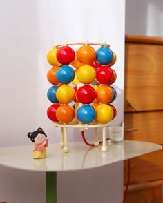 there is a small toy on top of a table with balls in the shape of a tower