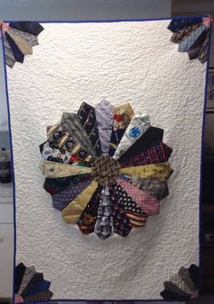 a quilted wall hanging with ties on it's side and an american flag in the middle