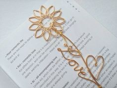 a bookmark with the word love written on it and a flower in the middle