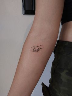 a woman's arm with a small tattoo on the left side of her arm