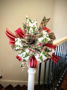 a christmas bow on top of a banister