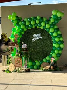 a large balloon arch with green balloons on it