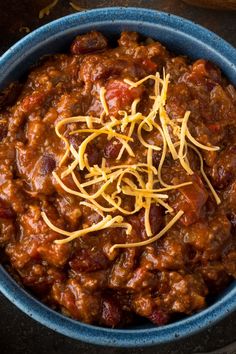 a blue bowl filled with chili and cheese