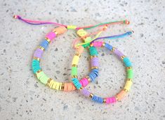 three bracelets with colorful beads are on the ground