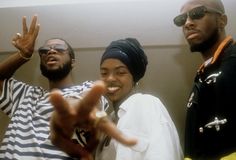 three young men standing next to each other and making the peace sign with their hands