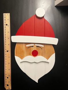 a wooden santa face with a ruler next to it