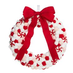 a wreath with red and white pom - poms on it