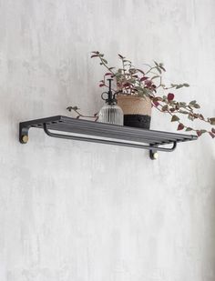 a potted plant sitting on top of a metal shelf next to a white wall