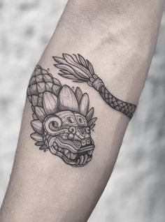 a black and white tattoo on the arm of a person with a dragon head in it