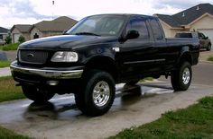 a black pick up truck parked in front of a house