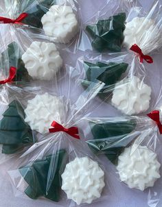 christmas cookies wrapped in cellophane and tied with red ribbon on white table cloth