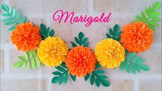 some paper flowers are hanging on a brick wall with the words margoad above them